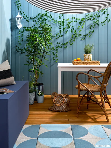 Outdoor dining area with wooden fence painted in Resene Bluff