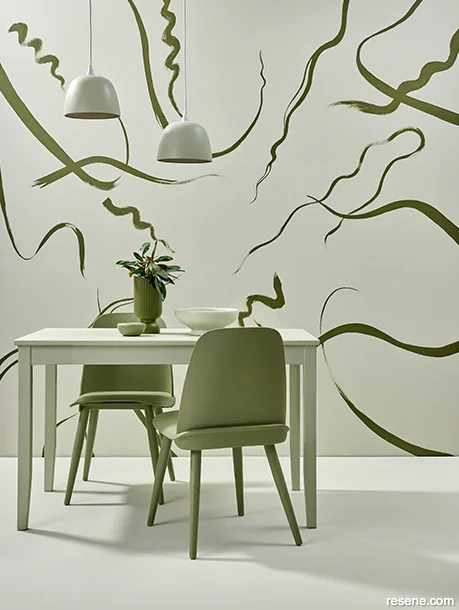 Green dining room with a dramatic feature wall in earthy and fresh green tones