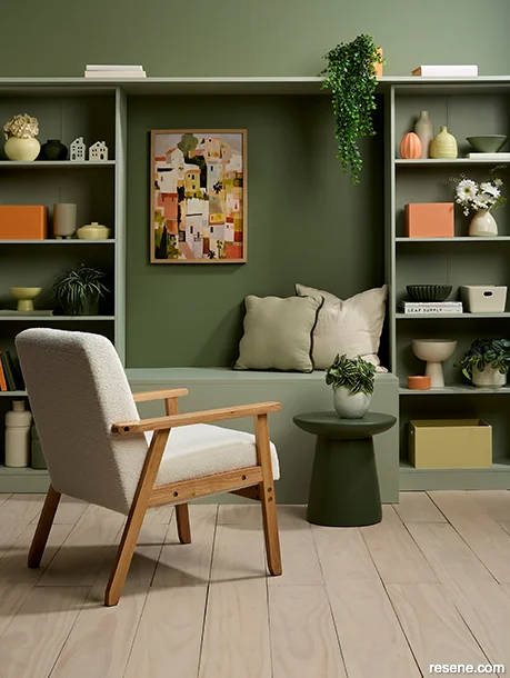 Sitting room painted with varied green shades, accented by terracotta and yellow accessories