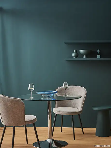 A refined dining room in dark blue green