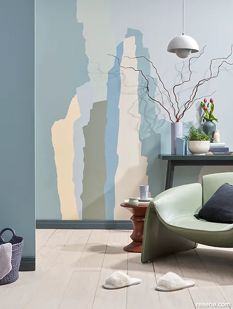A living area with a painted abstract mural on a feature wall