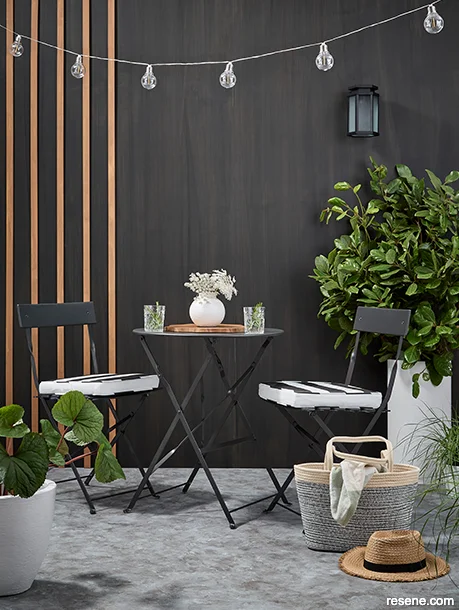 An outdoor dining area painted with charcoal moody hues