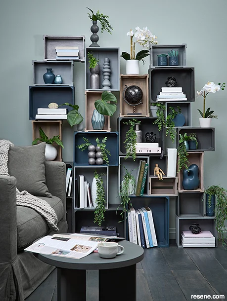 A lounge with a DIY crate shelving unit - room painted in grey-blue shades