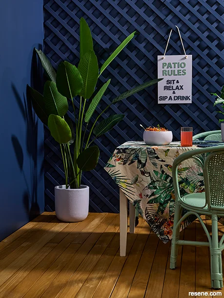 An outdoor dining room in the maximalist style - bold hues and lush plants