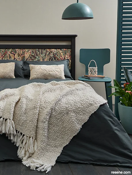 A neutral bedroom with pops of blue-green on accessories