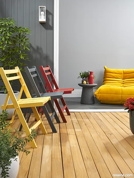 A patio and interior connected with sunny yellow and red accessories