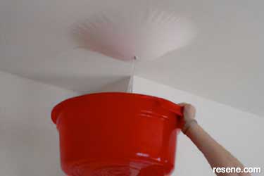 A water bubble in a ceiling being held by paint